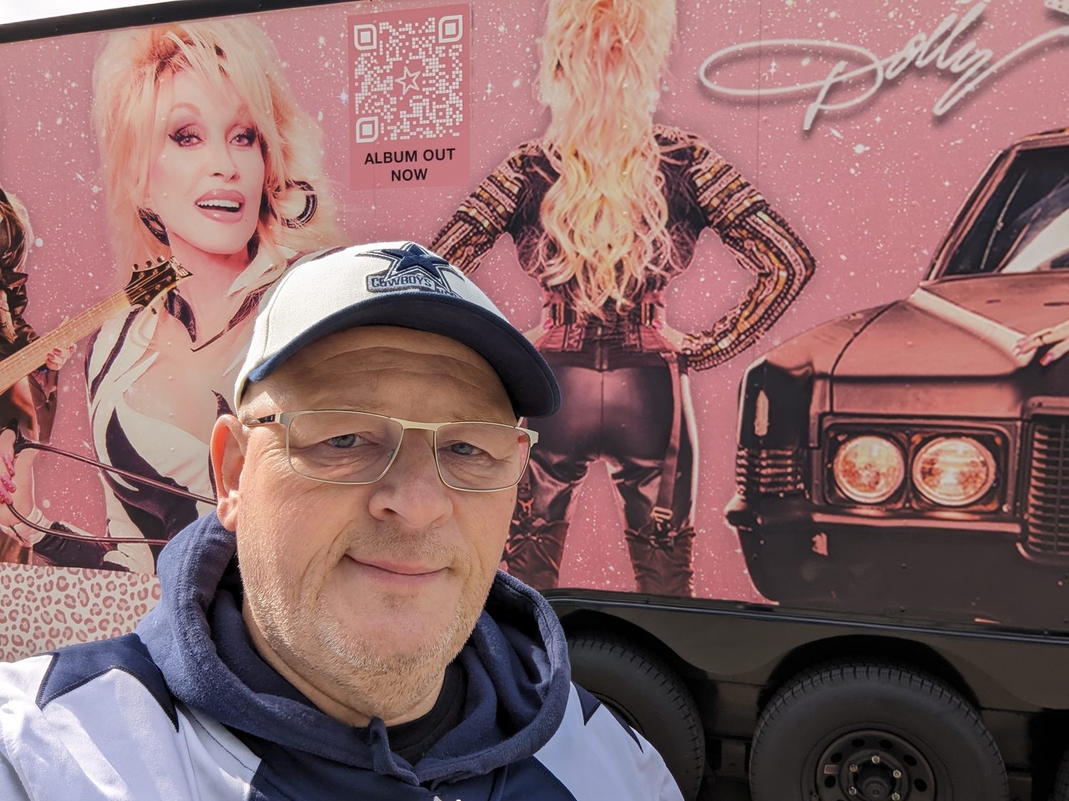 Selfie vor einem Truck mit Dolly-Parton-Werbung